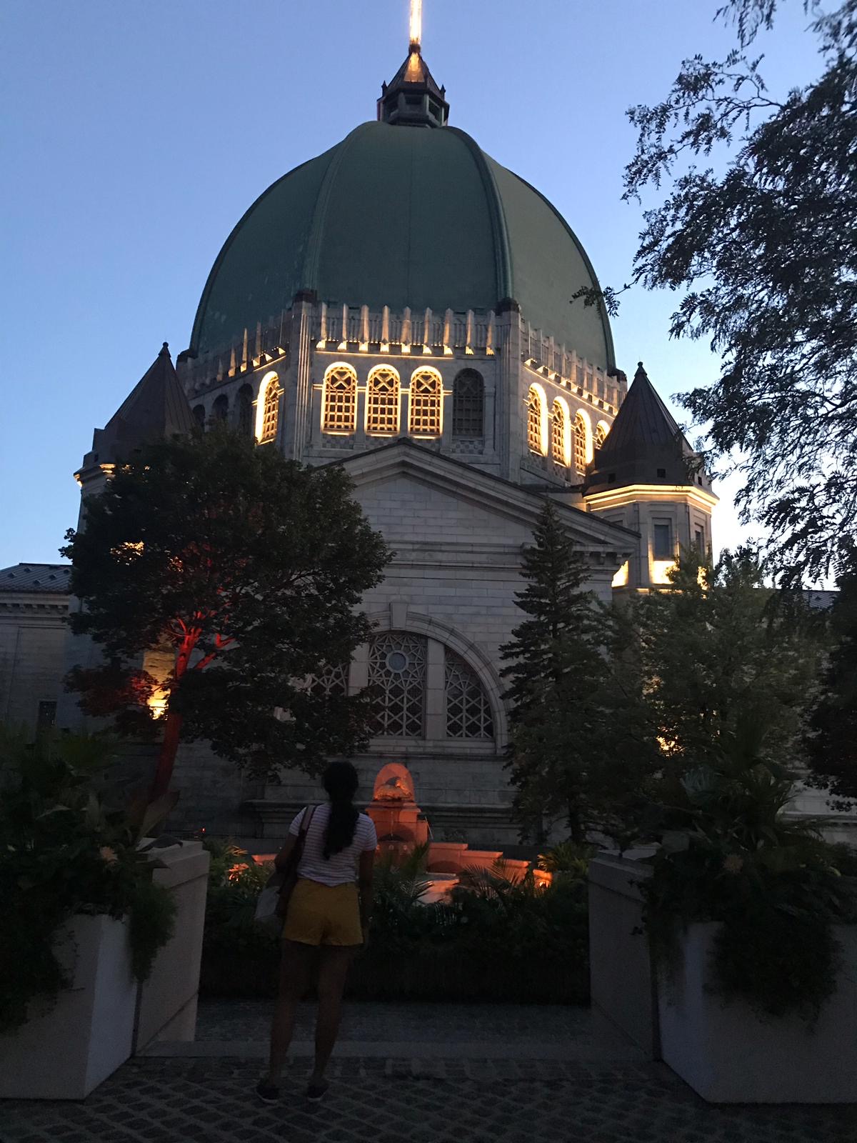 Standing in front of a domed basilica at dusk